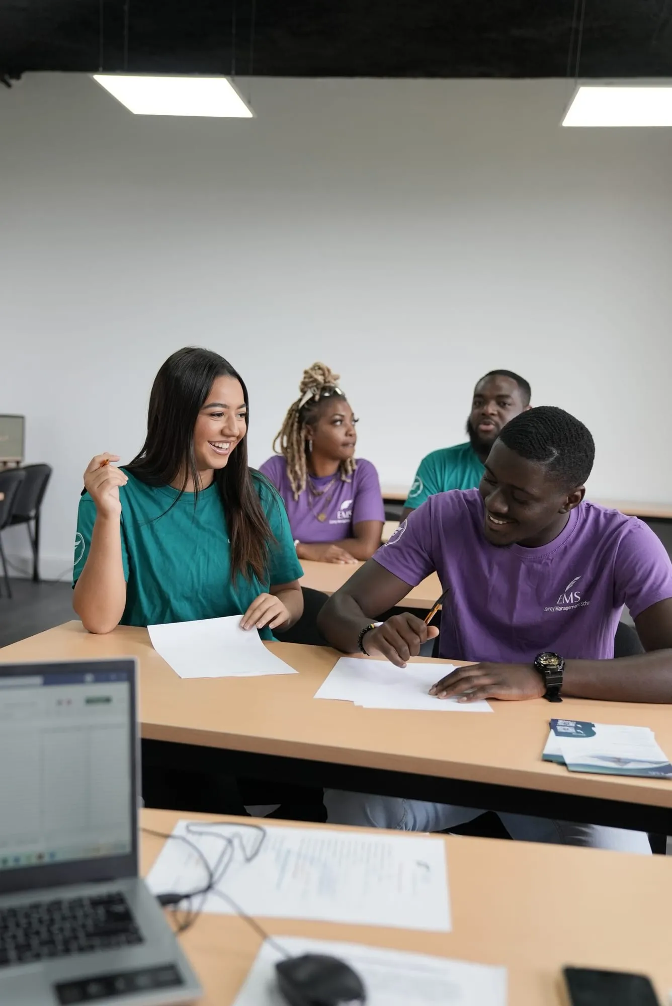 Des étudiants d’EMS échangent en souriant pendant un cours